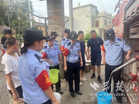 民輔警跟隨消防水車作業(yè)，通過肩挑手提的方式將清水送入行動不便的老年、殘障村民的家中（通訊員 李麗君 攝） (3).jpg.jpg
